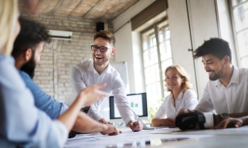 Business man and woman sitting around table at office and smiling