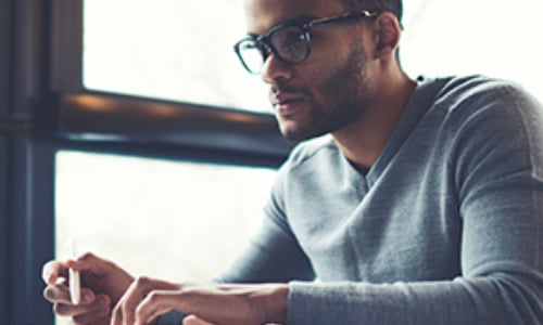 man with glasses looking at a computer