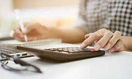 Woman using calculator to calculate interest