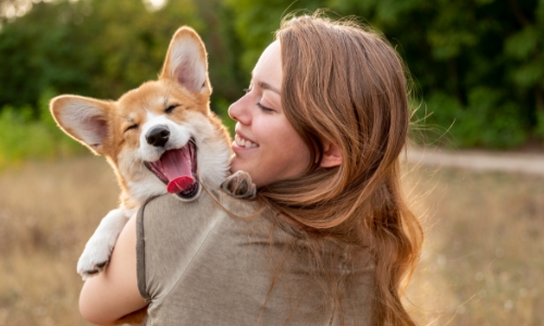 A person holding a happy dog