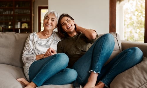 A retired parent and child sitting on the couch together