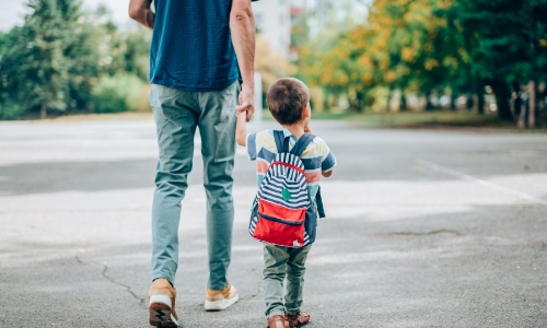 A parent and child walking to school