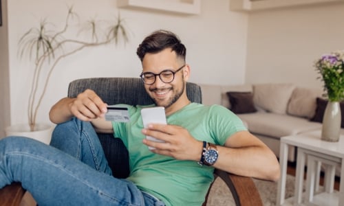 A person using the Central Bank credit card to shop online