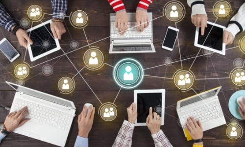 A group of people around a table and social media icons flying around