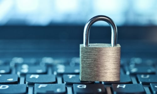 A metal padlock sitting on top of a computer keyboard