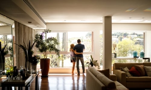 A couple standing in the window of their home