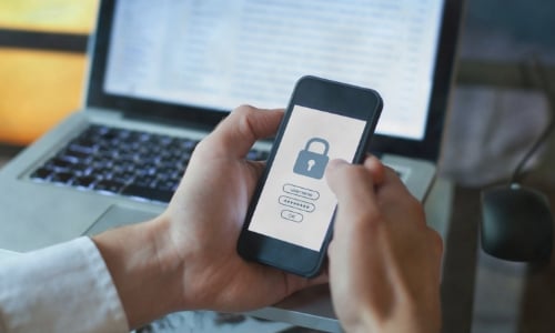 A person holding a cell phone with an image of a padlock