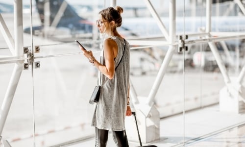 A person with a suitcase standing in an airport