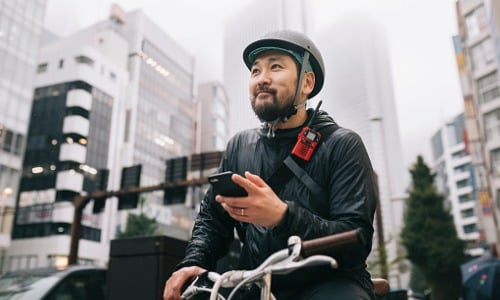 Bike messenger checking for directions on phone.