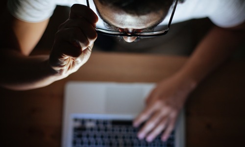 Computer hacker stealing information with laptop