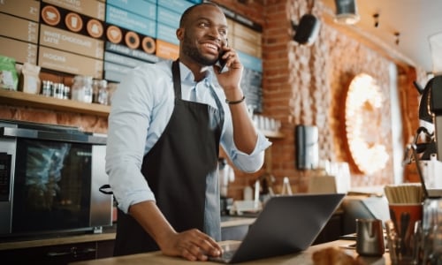 A business owner standing behind the counter in shop