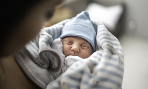 A parent holding a newborn baby