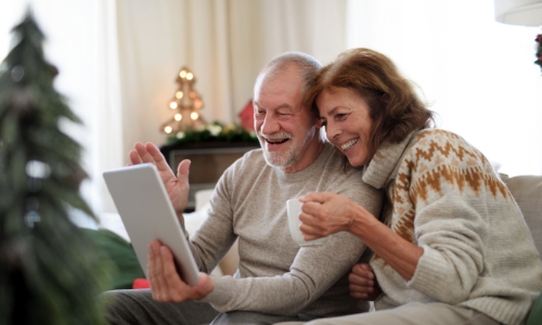 A retired couple having a video conversation on a tablet