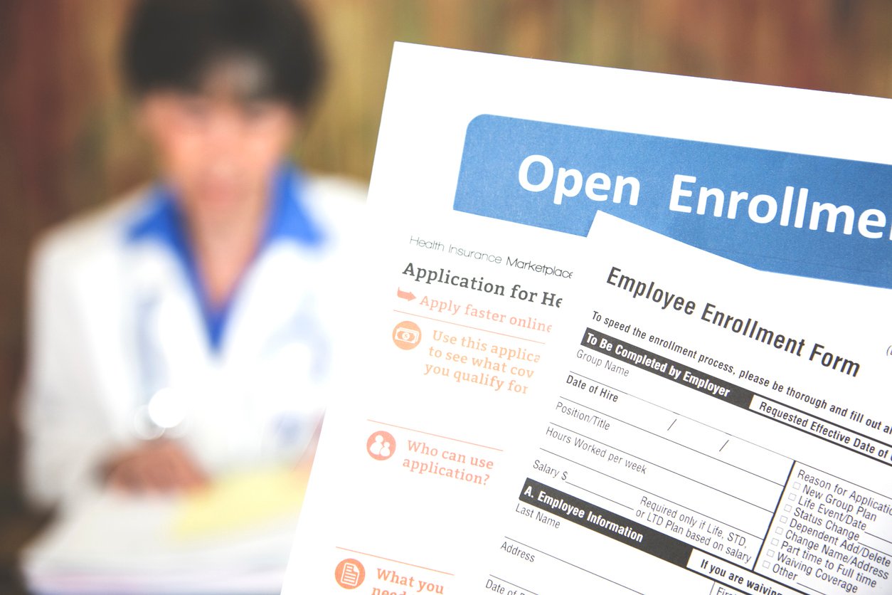 Open enrollment healthcare forms in front of a doctor.