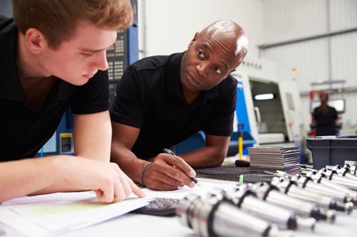 A man is mentoring a young man in a business setting