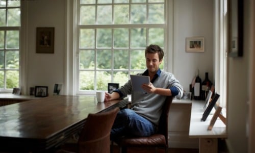 Man using tablet while drinking coffee