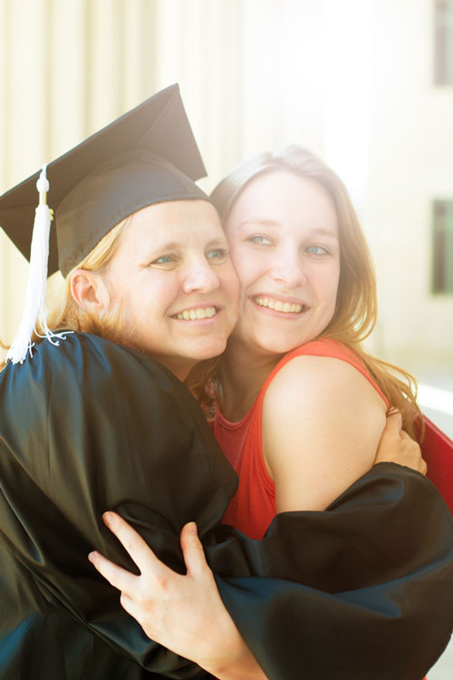A mother and daughter hug while at the mother's graduation