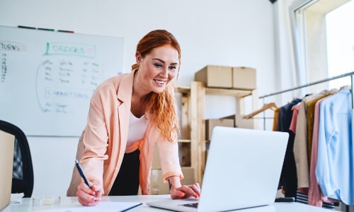 Woman over desk looking at computer