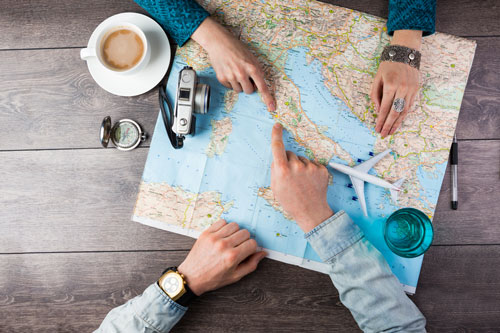 People sitting together reviewing a map to pick a vacation spot