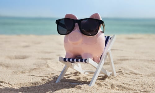 piggy bank with sunglasses at the beach