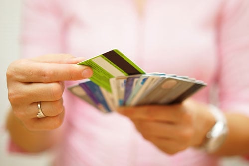 A person holding a stack of credit cards