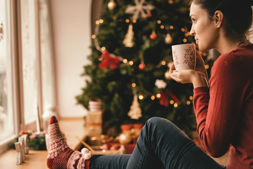 A person sitting by a Christmas Tree