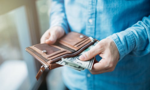 person pulling cash out of their wallet