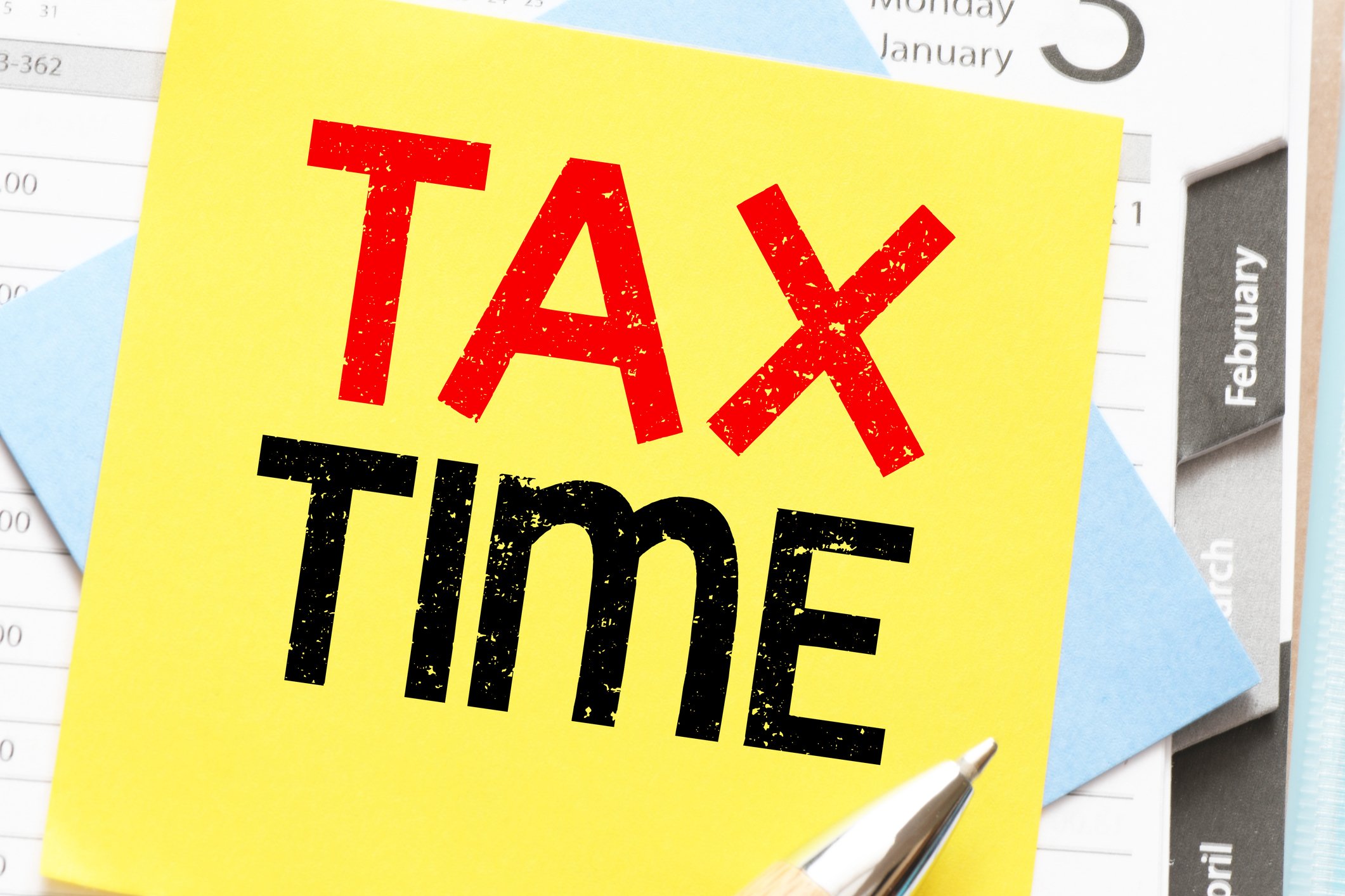 “Tax Time” written on sticky note on planner