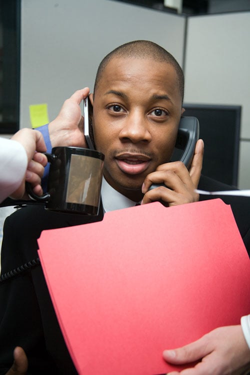 Employees handing a new employee office supplies