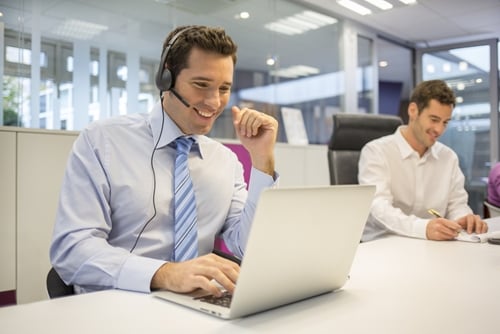 A man on his laptop taking a phone call