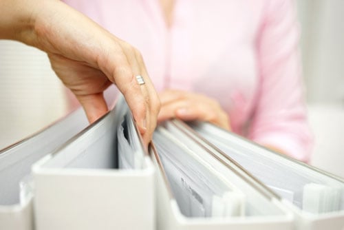 A woman is organizing a filing cabinet