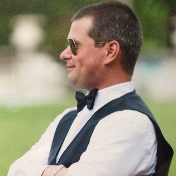 Greg standing in a suit