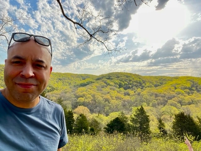 Chris standing with trees behind him