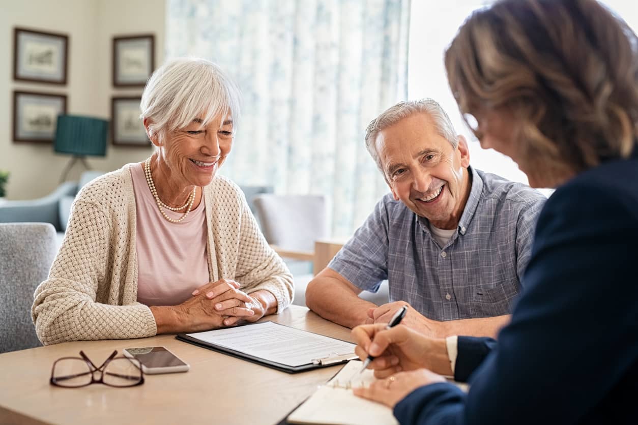 retirement age couple reviewing paperwork with financial advisor