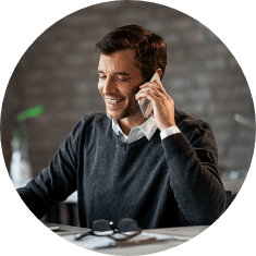 man talking on phone while looking at computer