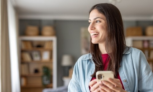 Smiling woman holding her phone