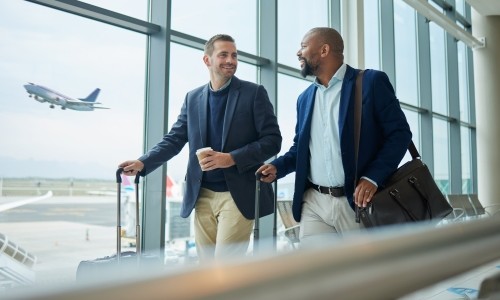 Two men at airport traveling for business