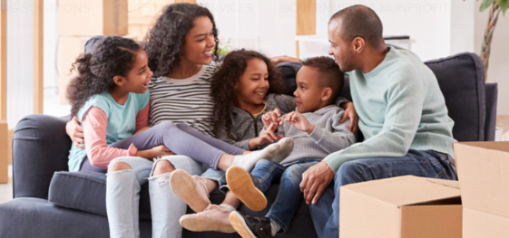 Family sitting on the couch after moving into their new home