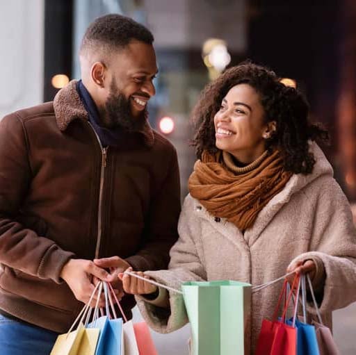 couple smiling at each other with shopping bags