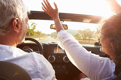 Explore Retirement Savings Solutions a couple cruising down the highway
