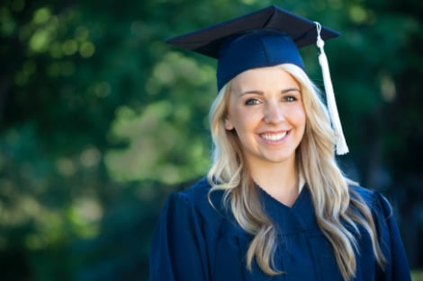 A woman smiling at the camera on graduation day