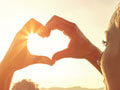 A woman forming the shape of a heart with her hands