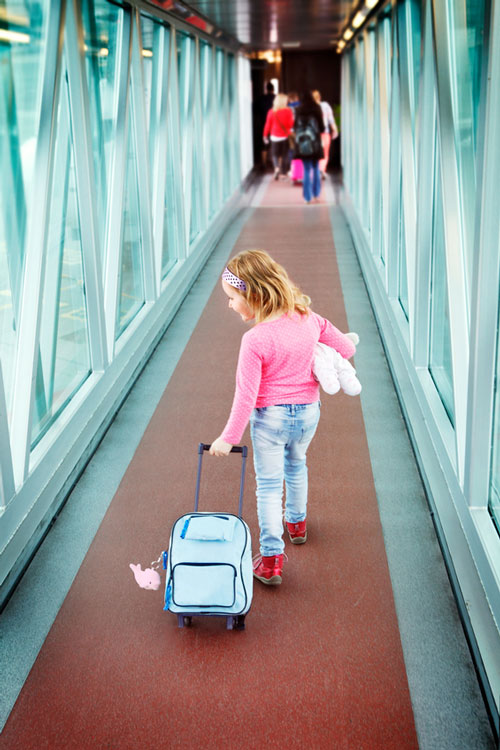 A child in an airport traveling alone