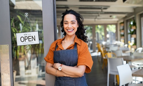 Successful female business owner at cafe entrance 