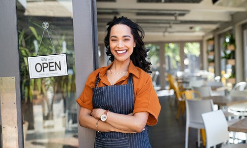 Successful female business owner at cafe entrance