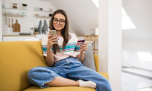 Teenage girl using mobile banking at home