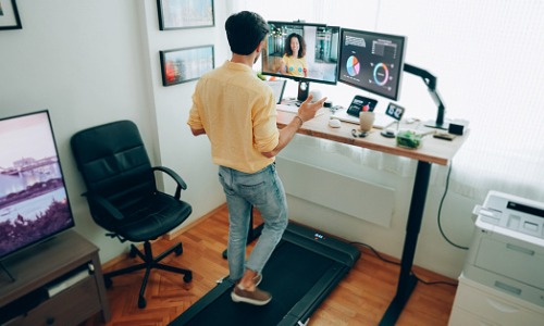 man working remote at standup desk home office
