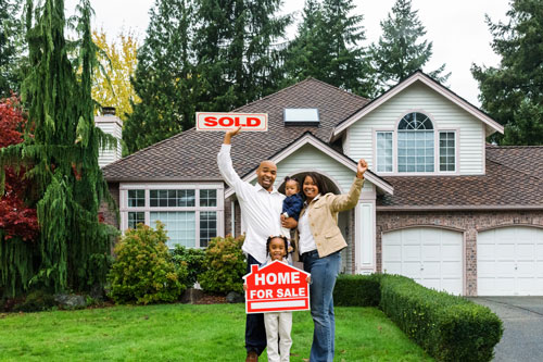 New homeowners standing outside their new home
