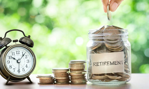 hand putting coin in a retirement money jar sitting next to clock