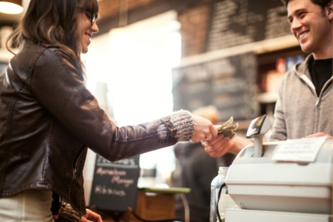 Woman paying business owner in cash